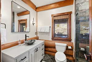 Full bathroom with vanity, an enclosed shower, a wainscoted wall, and granite tiled floors