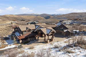 View of front of home with a mountain view, stone siding, and a garage