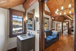 Bar area featuring wood ceiling, dark wood-type flooring, plenty of natural light, appliances with stainless steel finishes, and pendant lighting