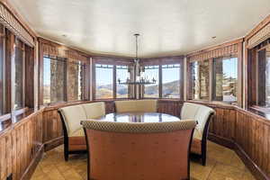 Sunroom / solarium with stone tile floors, wood walls, healthy amount of natural light, and a mountain view
