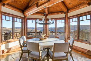 Sunroom featuring a chandelier and a mountain view