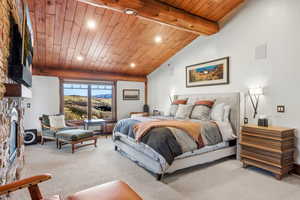Bedroom featuring a stone fireplace, recessed lighting, wooden ceiling, carpet flooring, and a mountain view