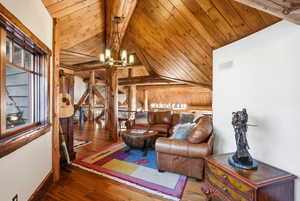 Living area featuring wood ceiling, wood-type flooring, and a chandelier