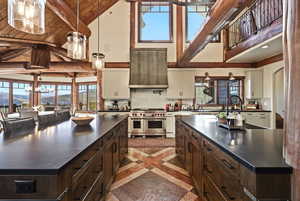 Kitchen with a chandelier, inlaid floor details, pendant lighting, double oven range, and dark brown cabinetry