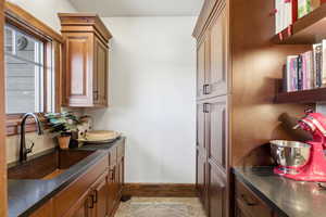 Kitchen with dark stone countertops and brown cabinetry