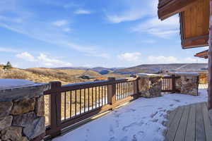 Snow covered deck featuring a mountain view