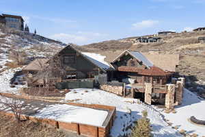 View of front facade with a deck with mountain view, stone siding, stairs, and a tile roof