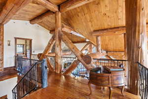 Living room with hardwood / wood-style floors, a wood ceiling with exposed beams, and high vaulted ceiling