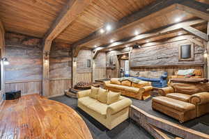 Cinema featuring wooden walls, wainscoting, a wooden ceiling with exposed beams, and hardwood / wood-style floors