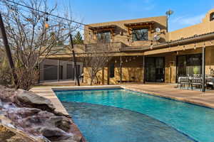 Back of property with a patio area, stucco siding, an outdoor pool, and outdoor dining area