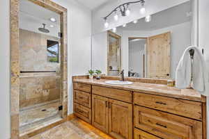 Primary Suite – En-Suite Full Bathroom. Full bathroom with vanity, a shower stall, stone tile floors, and recessed lighting