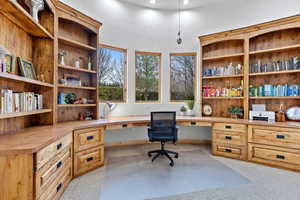 Office area featuring built in study area and light carpet