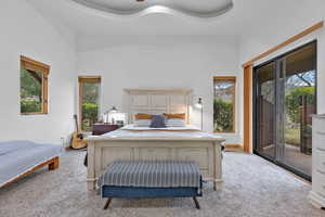 Primary Suite – Pool Patio Access. Carpeted bedroom with access to exterior, ceiling fan, and a raised ceiling