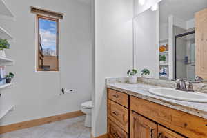 Bedroom #2 – En-Suite Full Bathroom. Full bathroom with vanity, light tile patterned flooring, and a shower stall