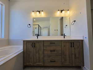 Full bathroom with double vanity, a stall shower, and a garden tub