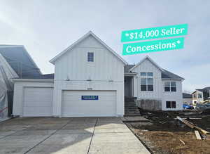 Modern farmhouse with board and batten siding, an attached garage, a shingled roof, and concrete driveway