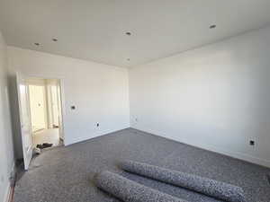 Carpeted spare room featuring baseboards