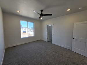 Unfurnished bedroom with dark carpet, a ceiling fan, and recessed lighting