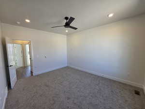 Spare room with dark carpet, a ceiling fan, and recessed lighting