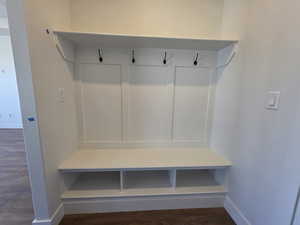 Mudroom featuring dark wood-style floors and baseboards