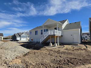 Back of property featuring roof with shingles and a wooden deck