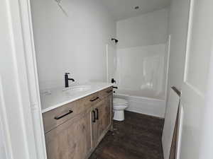 Bathroom with vanity, dark wood-style floors, and shower / bathtub combination