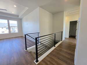 Hall featuring an upstairs landing, dark wood-type flooring, and recessed lighting