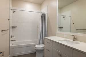 Bathroom featuring shower / bath combination with curtain, vanity, and dark tile patterned flooring