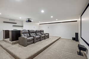 Home theater room with light colored carpet and recessed lighting