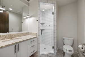 Bathroom with a stall shower, vanity, and tile patterned flooring