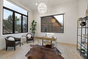 Home office featuring light wood finished floors and a chandelier