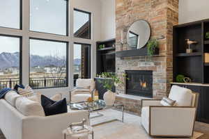 Living area featuring a towering ceiling, a brick fireplace, a mountain view, and wood finished floors