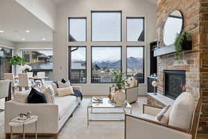 Living area featuring a large fireplace, a mountain view, high vaulted ceiling, wood finished floors, and recessed lighting