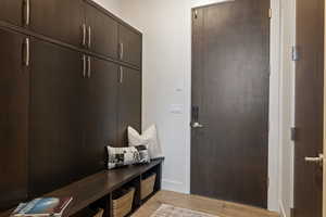 Mudroom with light wood-type flooring and baseboards