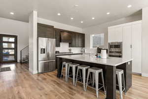 Kitchen with stainless steel appliances, quartz countertops,  and view into entryway