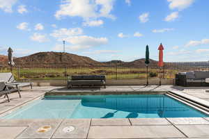 Private pool located off the main level family room/kitchen area with a view of Coral Canyon Golf Course