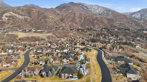 Aerial view of property and surrounding area featuring nearby suburban area and mountains