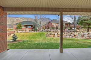 View of grassy yard with a mountain view and a patio area