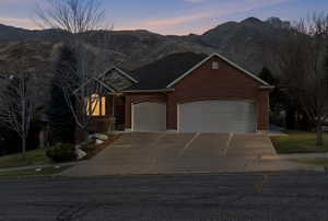 View of front facade featuring brick siding, a mountain view, and driveway