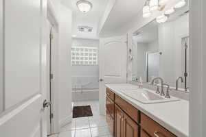 Bathroom with vanity, light tile patterned floors, a bathtub, and a shower