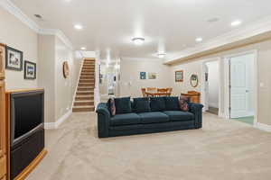 Living area with stairway, light colored carpet, crown molding, and recessed lighting