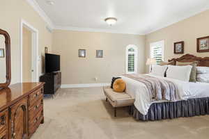 Bedroom with light carpet and crown molding