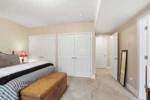 Bedroom featuring multiple closets and light carpet