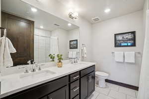Full bathroom with double vanity, a shower with shower curtain, and recessed lighting