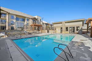 Community pool with a pergola and a patio area