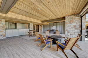 Wooden deck featuring a patio area and a fire pit