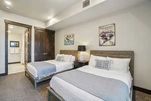 Bedroom featuring a closet, carpet floors, ensuite bath, and recessed lighting