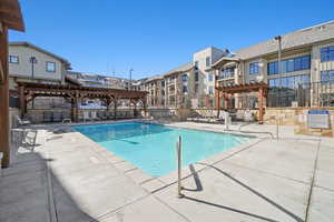 Community pool with a pergola and a patio area