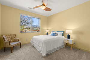 Carpeted bedroom featuring a mountain view and a ceiling fan