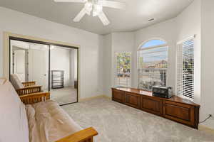 Living area with light carpet and a ceiling fan